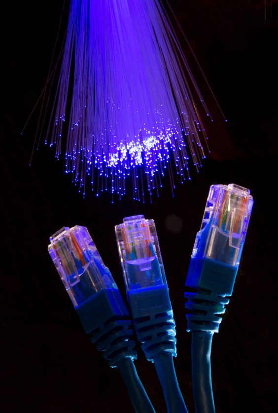 Nahaufnahme von Glasfaserleitungen mit leuchtenden Lichtpunkten zur optischen Datenübertragung.